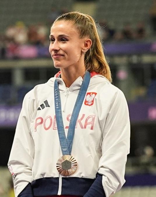 Natalia Bukowiecka uśmiechnięta, rozmawiająca z fanami po zawodach, trzymająca medal, w swobodnym stroju sportowym.