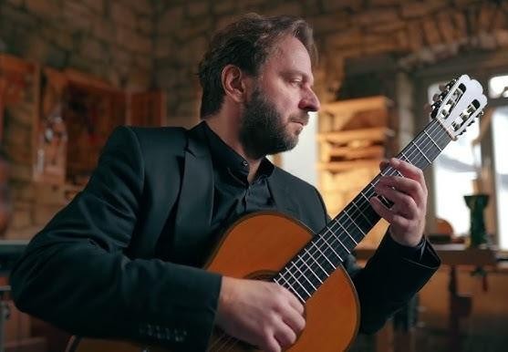 Symboliczne przedstawienie edukacji i kwalifikacji gitarzysty klasycznego, z nutami, gitarą i elementami akademickimi.