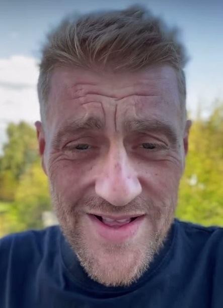 Tomasz Jakubiak w akcji podczas programu kulinarnego, prezentuje swoje umiejętności gotowania.