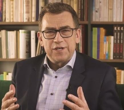 Maciej Orłoś na planie filmowym lub w studiu telewizyjnym, ukazujący jego zaangażowanie w karierę aktorską i dziennikarską.