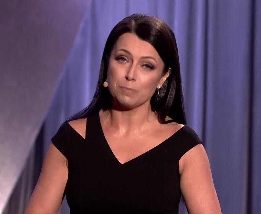 Adrianna Borek w trakcie występu kabaretowego, z zabawną mimiką i przewracającymi oczami, ukazująca jej charakterystyczny humor sceniczny.
