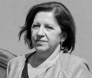 Wnętrze biura z widocznym stołem konferencyjnym i dokumentami, sugerujące miejsce ważnego spotkania lub przesłuchania.
