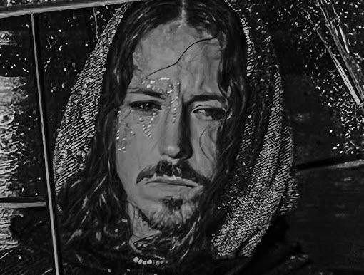 Michał Szpak na zbliżeniu, prezentujący swój charakterystyczny, ekstrawagancki styl, z długimi włosami, wyrazistym makijażem i unikatowym strojem, podkreślający jego indywidualność artystyczną.